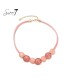 Korte halsketting met roze disk en glanzende details