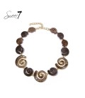 Bruine korte halsketting met spiralen en goudkleurige accenten